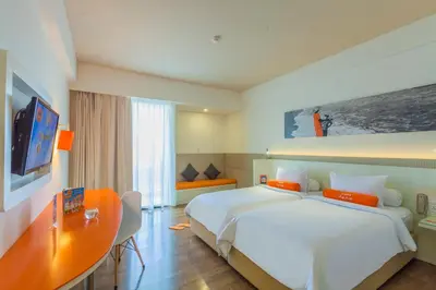 a hotel room with a large bed and a desk at HARRIS Hotel Seminyak in Seminyak