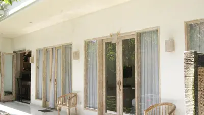 a living room with windows and chairs at Sugiras Living in Denpasar