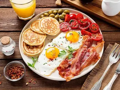 a plate of breakfast food with eggs bacon and tomatoes at Casa Amarta Canggu - Boutique Lofts & Detox SPA in Canggu