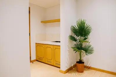 a kitchen with yellow cabinets and a potted plant at Casa Amarta Canggu - Boutique Lofts & Detox SPA in Canggu