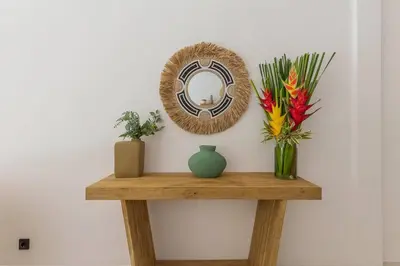 a table with a mirror and flowers on a wall at Villa Alamanda Livia Seminyak Design spacious 2bdr and private pool in Seminyak