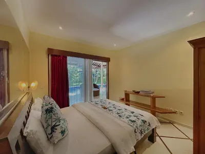 a bedroom with a large bed and a window at Villa Yauda - Charming 3BR w/Private pool & Garden in Seminyak