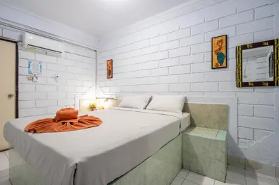 a bedroom with a bed with a hat on it at Ammara Legian By Vilarisi - 8 Minute Walk To The Beach in Legian