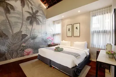 a bedroom with a large bed with a tropical wallpaper at Villa Giva Seminyak - 2 Bedrooms Seminyak in Seminyak