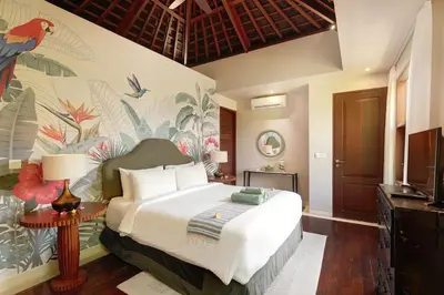 a bedroom with a king sized bed with a tropical wallpaper at Villa Giva Seminyak - 2 Bedrooms Seminyak in Seminyak