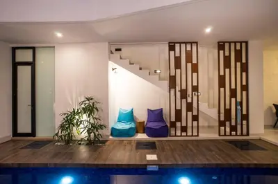 a room with two blue pillows and a staircase at Berawa Bali Beach Villas Canggu in Canggu