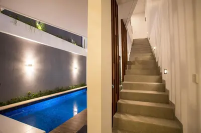a staircase leading to a pool in a house at Berawa Bali Beach Villas Canggu in Canggu