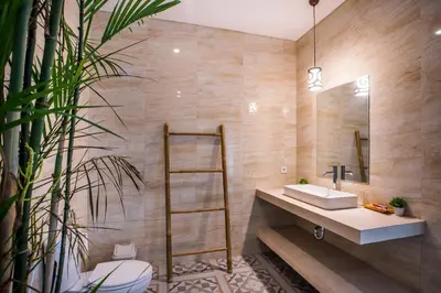 a bathroom with a sink and a mirror at Berawa Bali Beach Villas Canggu in Canggu