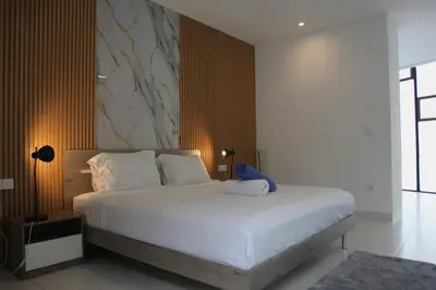 a bedroom with a bed with a blue stuffed animal on it at Berawa Bali Beach Villas Canggu in Canggu