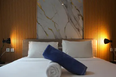 a bed with a blue pillow sitting on top of it at Berawa Bali Beach Villas Canggu in Canggu