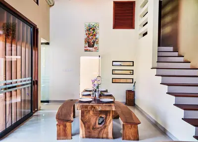 a room with a wooden table and a staircase at Dreamscape Bali Villas Canggu in Canggu