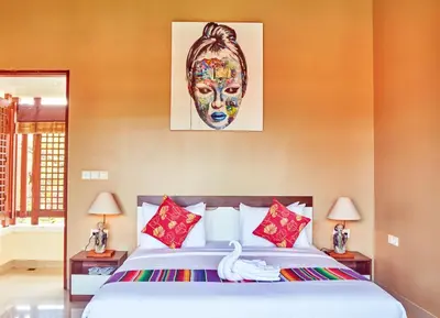 a bedroom with a bed with a picture of a woman at Dreamscape Bali Villas Canggu in Canggu
