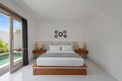 a bedroom with a bed and a pool at Serenity Villa by Betterplace in Kerobokan