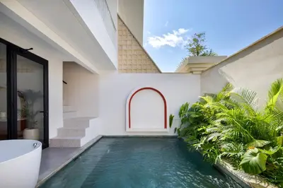 an indoor swimming pool in the backyard of a house at Sayang Villa Bali in Kerobokan