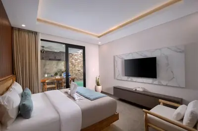 a hotel room with a bed and a television at Sayang Villa Bali in Kerobokan