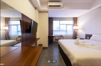 a hotel room with a bed and a desk with a tv at LBV Ambengan Tenten in Denpasar