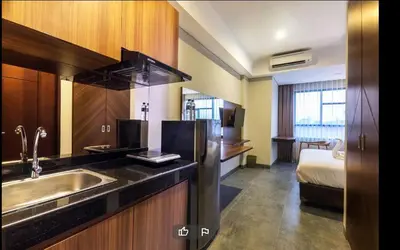 a kitchen with a sink and a bed in a room at LBV Ambengan Tenten in Denpasar