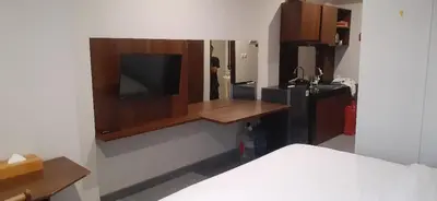 a room with a kitchen with a tv on a wall at LBV Ambengan Tenten in Denpasar