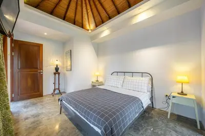 a bedroom with a bed and two lamps on two tables at Villa Arumanis in Canggu