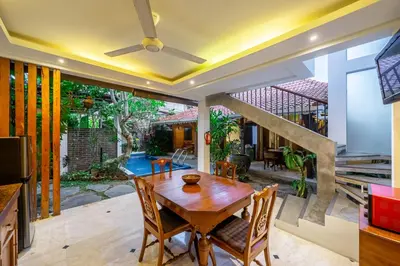 a dining room with a wooden table and chairs at Villa Arumanis in Canggu