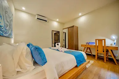 a bedroom with a bed with blue pillows and a desk at Villa Domino - *NEW* Luxurious 2BR w/ Pool @Central Seminyak in Seminyak