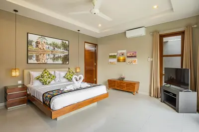 a bedroom with a bed and a flat screen tv at Villa 500m2 with 14m Pool, BBQ, Pinball - Seminyak in Seminyak