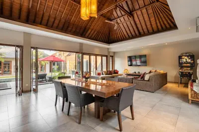 a living room with a wooden table and chairs at Villa 500m2 with 14m Pool, BBQ, Pinball - Seminyak in Seminyak