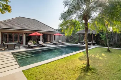 a backyard with a pool and a house with a palm tree at Villa 500m2 with 14m Pool, BBQ, Pinball - Seminyak in Seminyak