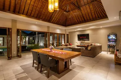 a living room with a wooden table and a couch at Villa 500m2 with 14m Pool, BBQ, Pinball - Seminyak in Seminyak
