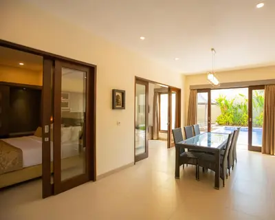 a dining room with a table and chairs and a bed at Luxotic Private Villa and Resort in Nusa Dua