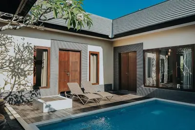 a house with a swimming pool next to a house at Luxotic Private Villa and Resort in Nusa Dua