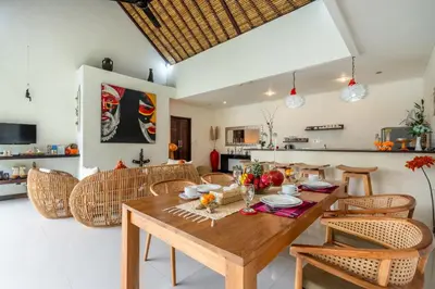 a kitchen and dining room with a wooden table and chairs at Villa Ricci Seminyak in Kerobokan