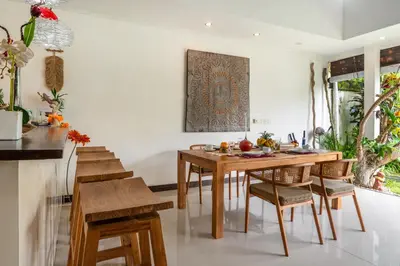 a dining room with a wooden table and chairs at Villa Ricci Seminyak in Kerobokan