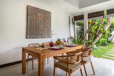 a dining room with a wooden table and chairs at Villa Ricci Seminyak in Kerobokan