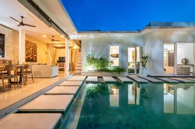 a house with a swimming pool with a dining room at Villa Khanphi Seminyak in Seminyak