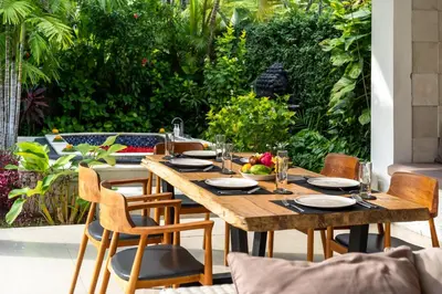 a wooden table and chairs on a patio at Villa Khanphi Seminyak in Seminyak