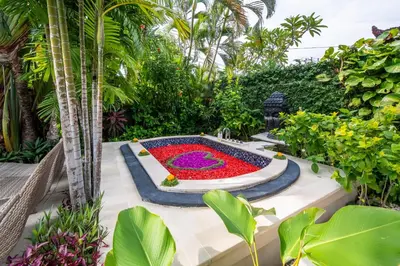 a garden with a large flower garden in the middle at Villa Khanphi Seminyak in Seminyak