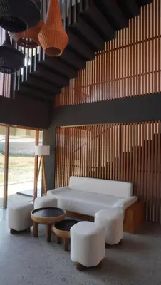 a room with a bed and a table and chairs at The Fields Hotel and Apartment in Seminyak
