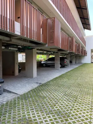 a parking lot with a car parked underneath a building at The Fields Hotel and Apartment in Seminyak