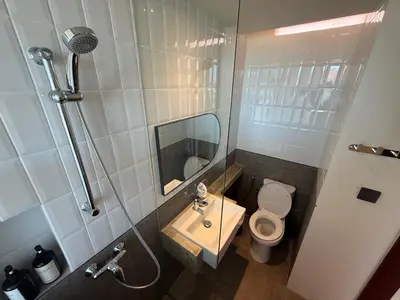 a bathroom with a toilet and a sink and a shower at The Fields Hotel and Apartment in Seminyak