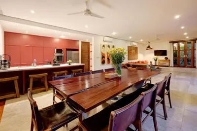 a kitchen and dining room with a wooden table and chairs at Villa Amira 5BR Villa 17m Pool Near Legian Beach in Legian