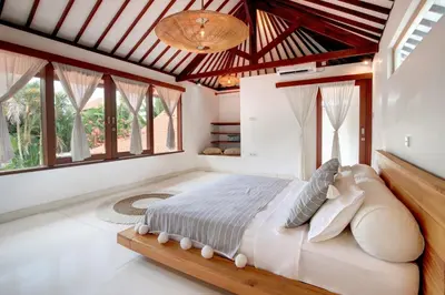 a bedroom with a large bed in a room with windows at Lepa Villa, Oasis in Legian in Seminyak