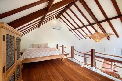 a bedroom with a bed in a room with wooden floors at Lepa Villa, Oasis in Legian in Seminyak