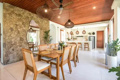 a kitchen and dining room with a wooden table and chairs at Colonial-style 4BR Villa, 400m to Canggu Beach in Canggu