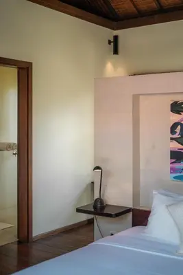 a bedroom with a bed and a lamp on a table at Villa Claudia - Chic 3BR Family Villa with Pool & Play near Seminyak in Kerobokan