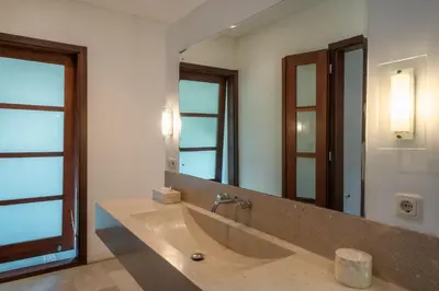 a bathroom with a sink and a large mirror at Villa Claudia - Chic 3BR Family Villa with Pool & Play near Seminyak in Kerobokan