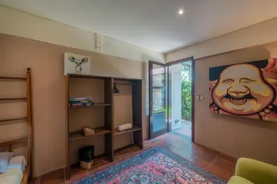 a living room with a painting of a face on the wall at Villa Claudia - Chic 3BR Family Villa with Pool & Play near Seminyak in Kerobokan