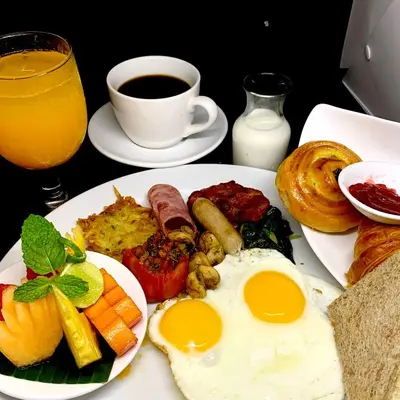 a plate of breakfast food with eggs and a cup of coffee at Villa Kubu Seminyak in Seminyak