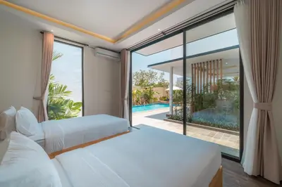 a bedroom with two beds and a large window at Villa Selikur 1 - Spacious 3BR Villa in Seminyak! Perfect location! in Seminyak