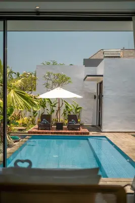 a swimming pool with two chairs and an umbrella at Villa Selikur 1 - Spacious 3BR Villa in Seminyak! Perfect location! in Seminyak